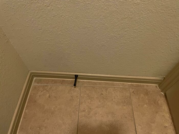 Close-up of a cracked tile floor in a home showing poor maintenance issues after people bought homes.