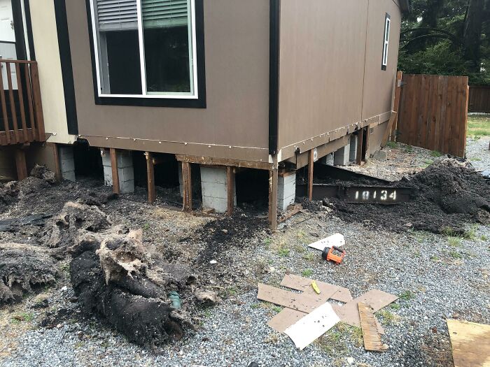 House raised on temporary supports with visible foundation damage and debris, illustrating regretted home purchase issues.