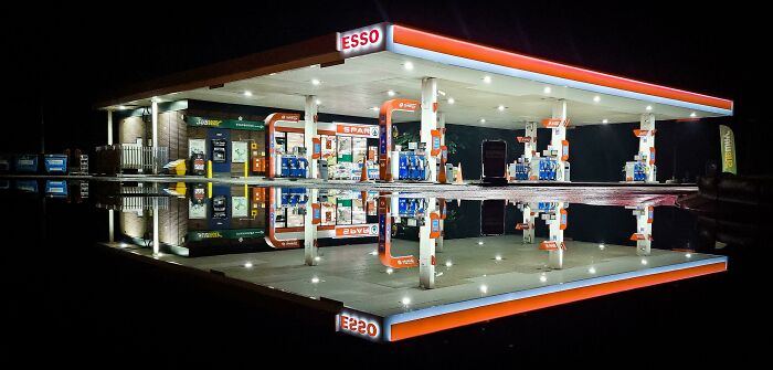 Esso gas station at night reflected perfectly on water, creating an unedited photo that might mess with your brain.