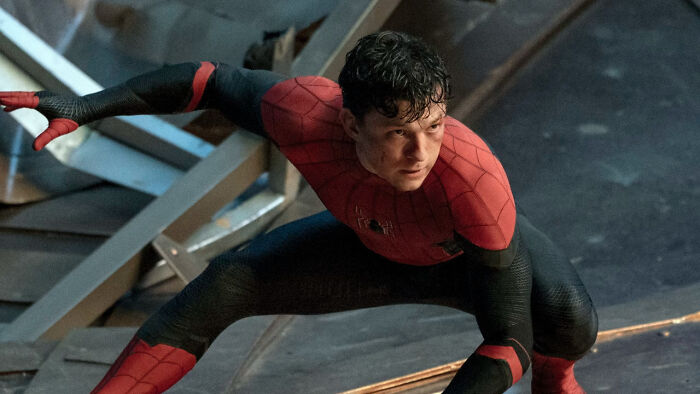 Tom Holland as Spider-Man crouching in his suit, highlighting a controversial change to the web-slinger character in Brand New Day.