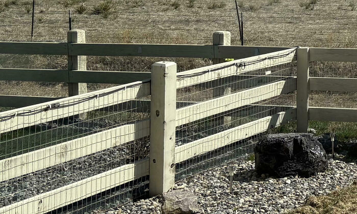 Rustic wooden fence in a dry, open area showcasing a quiet rural setting with minimal neighbors around.