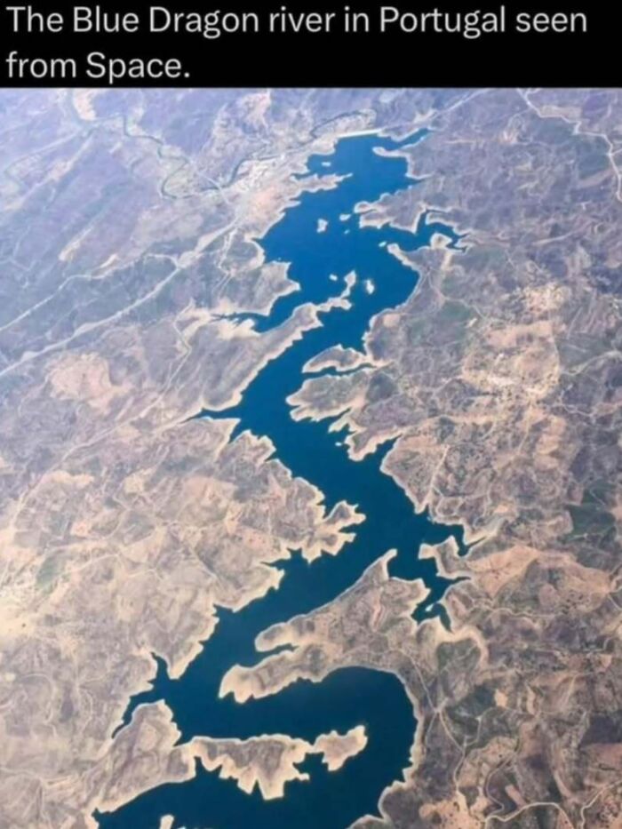 Blue Dragon river in Portugal seen from space, showcasing natural patterns in the wild landscape and water bodies.