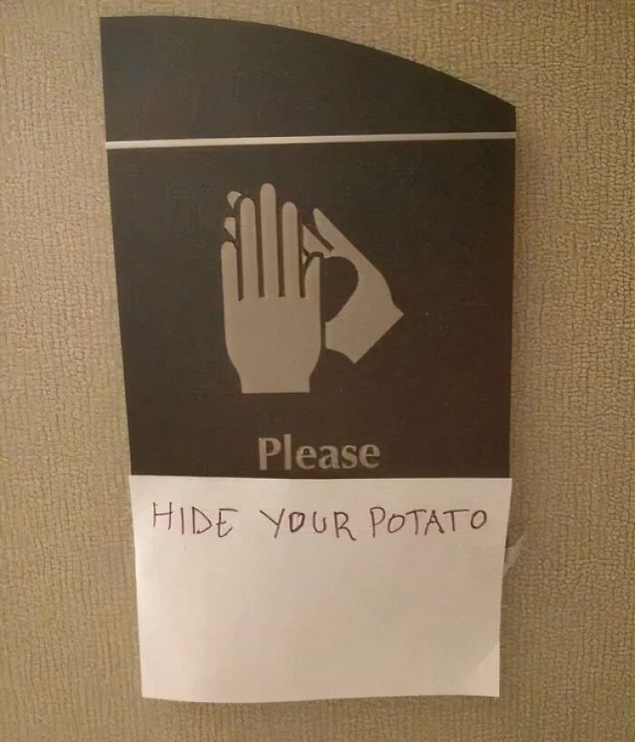 Sign with hand symbols and a handwritten note saying hide your potato as mild vandalism humor.
