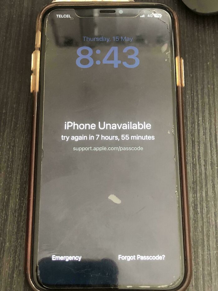 iPhone screen showing unexplainable lockout message with a countdown timer on a wooden surface