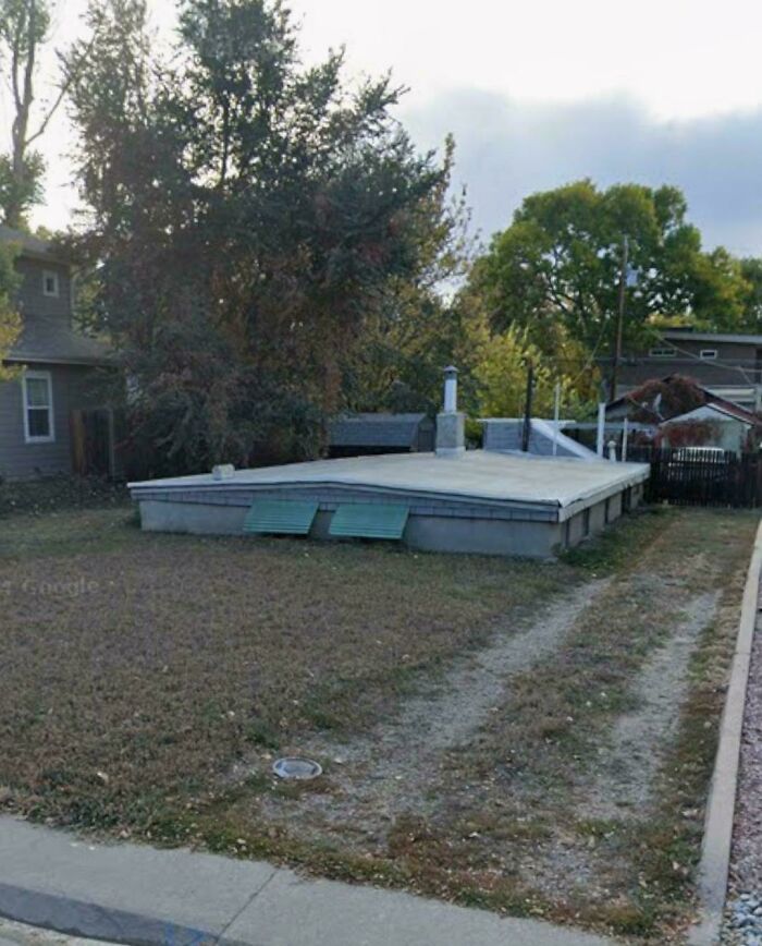 Weird and unexplainable image of a house with only a foundation and no walls in a residential area.