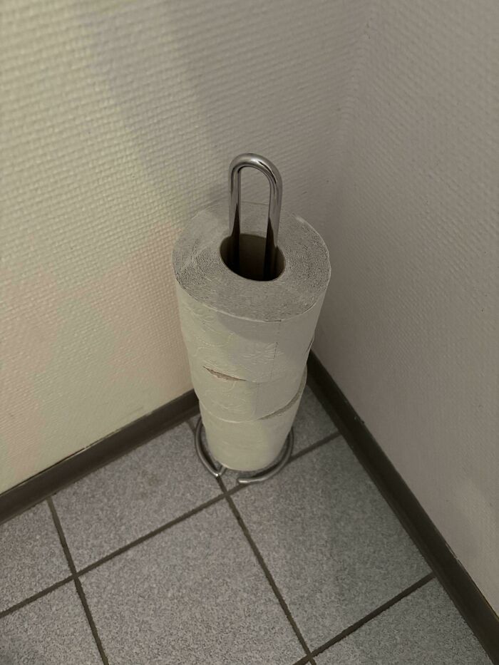 Toilet paper rolls stacked on a holder in a workplace corner, illustrating the shift in workplace environment and attitudes.