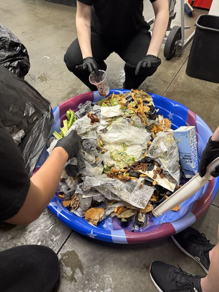 Workers sorting trash and food waste in a cluttered workplace setting, highlighting why no one wants to work anymore.