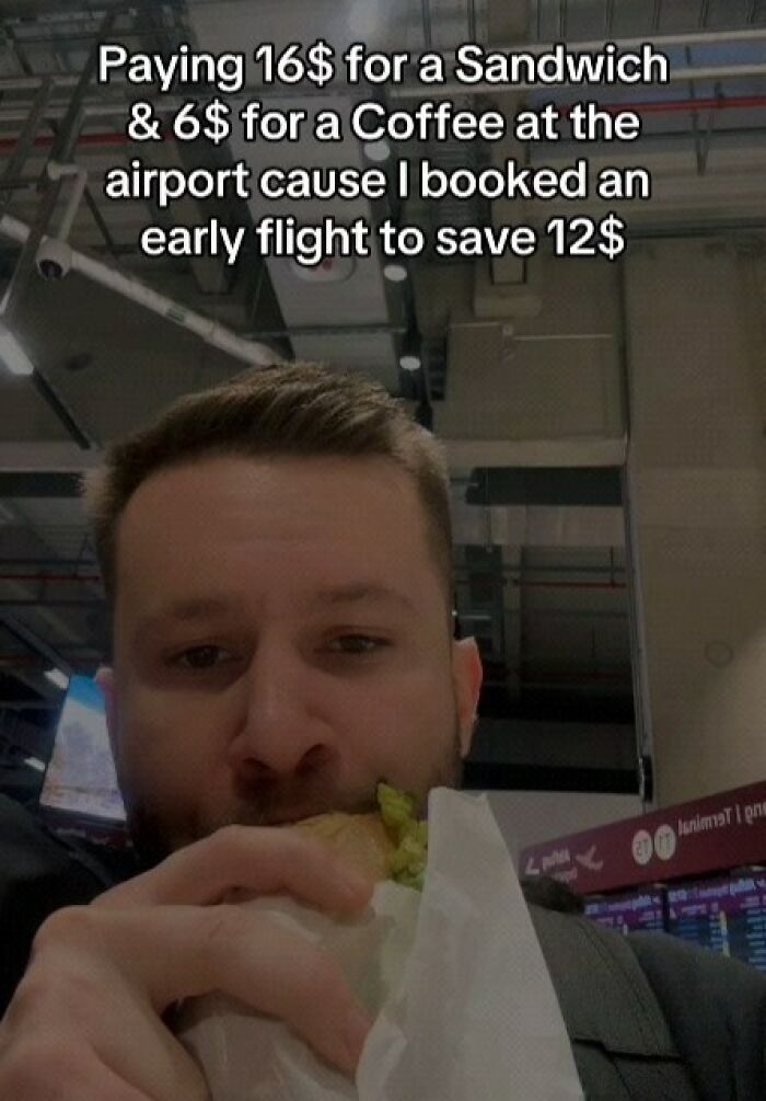 Man eating a sandwich at the airport, illustrating memes about spending money while trying to save on flights.
