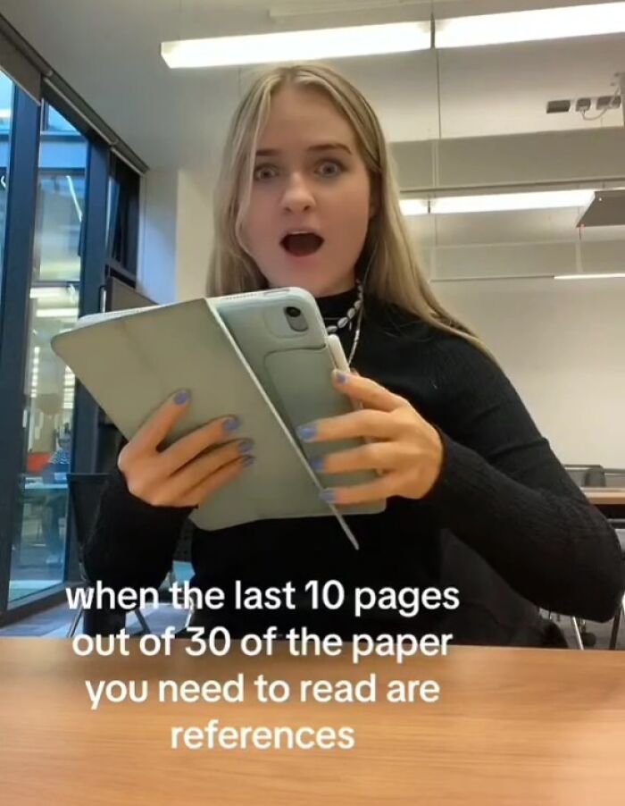 Young woman reacting in shock to reading on a tablet, relating to memes for entertainment and study frustration.