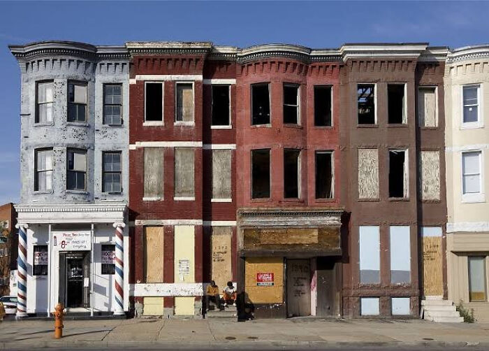 Abandoned urban hell row houses with boarded windows and decay