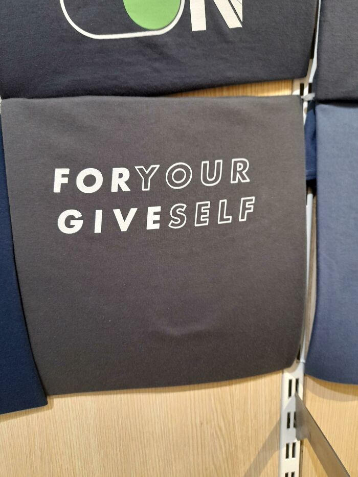 Hilariously bad t-shirt design with confusing text saying For Your Give Self on a folded black shirt.