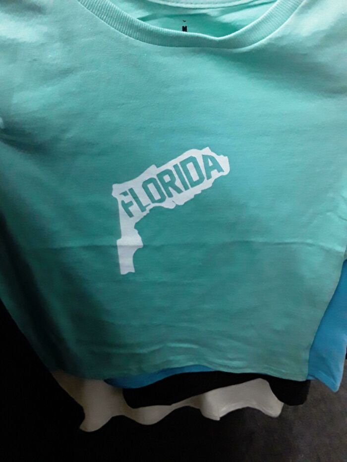 Light blue t-shirt with a humorous and incorrectly shaped Florida map design illustrating bad t-shirt designs.