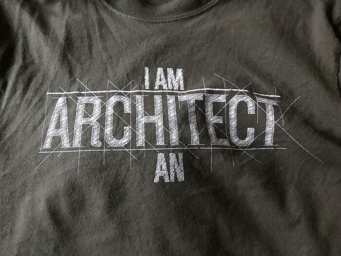 Black t-shirt with a hilariously bad design featuring the text "I AM ARCHITECT AN" in white graphic font.