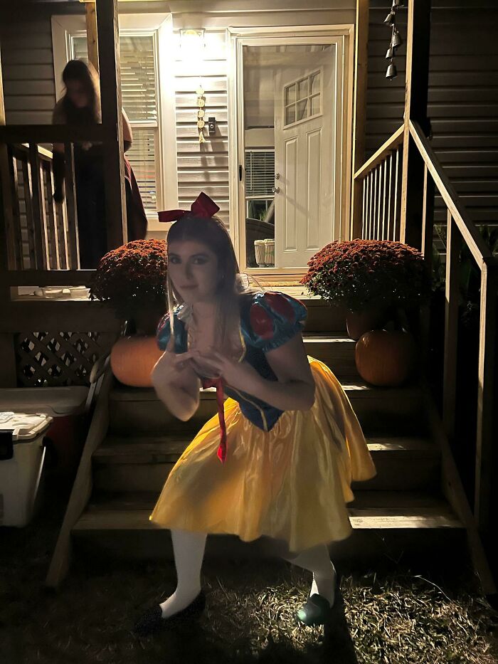 Young woman in Snow White costume posing creepily on porch steps at night in an unedited photo that might mess with your brain.