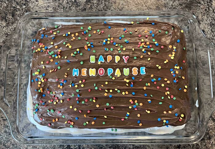 Chocolate frosted cake with colorful confetti and happy menopause message