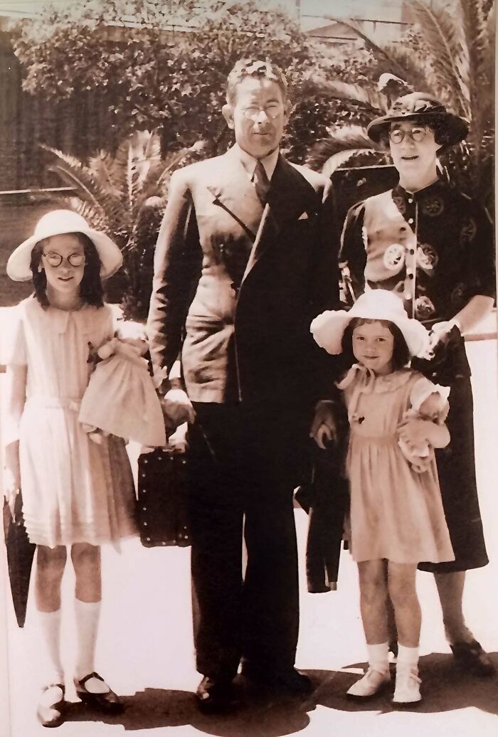 A candid old photo of a family of four posing outdoors, revealing what the world looked like generations ago.