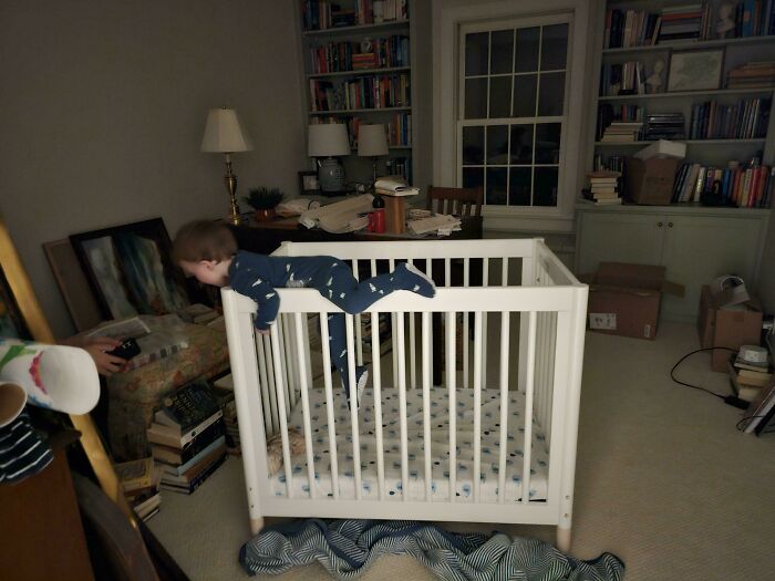 Toddler attempting to climb out of a crib, a funny and goofy moment from a great dad's perspective.