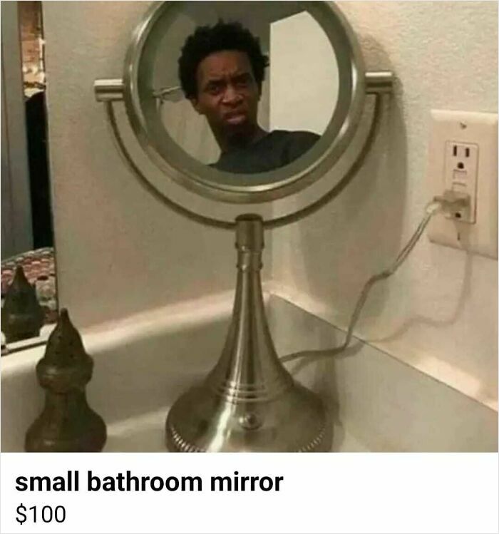 Reflection of confused man in small bathroom mirror plugged into wall socket, an unhinged Facebook Marketplace pic.