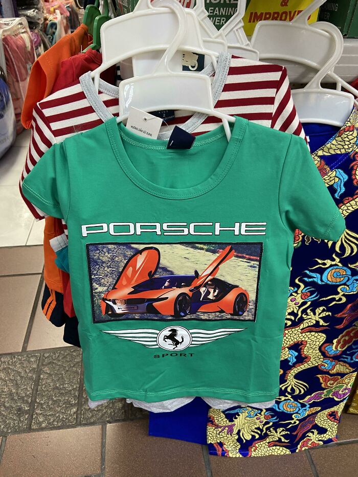 Green t-shirt with a car graphic and misspelled logo, example of hilariously bad t-shirt designs needing one more brain cell.