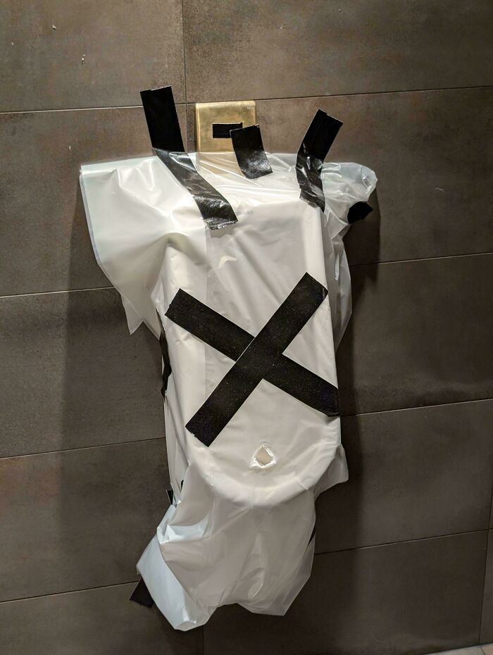 Toilet wrapped in plastic with black tape forming an X, symbolizing ungovernable first-world anarchist protest.