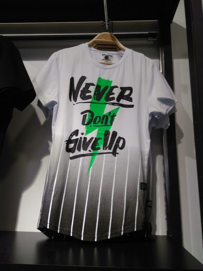 White and gray t-shirt with green lightning bolt and text never don't give up, an example of hilariously bad t-shirt designs on display