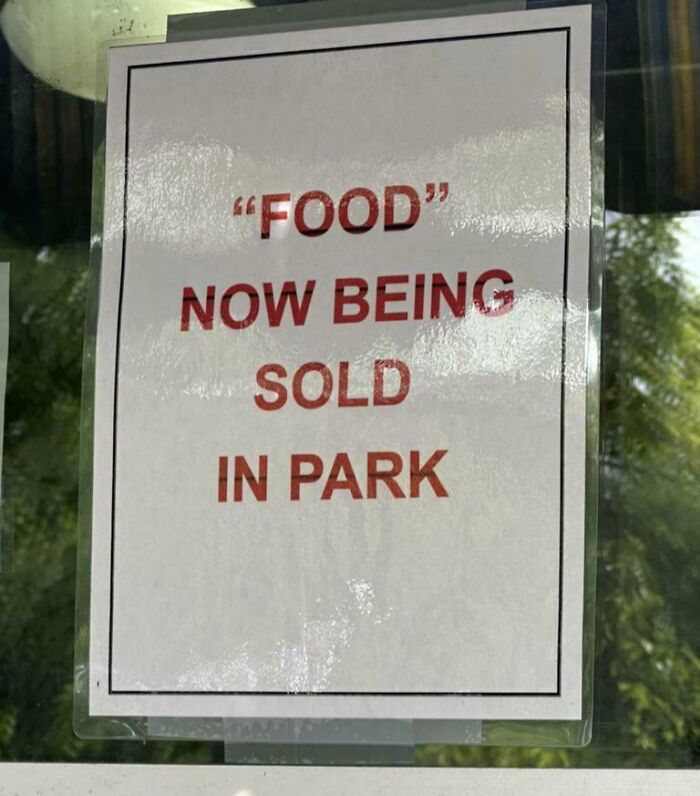 Sign with suspicious quotation marks around food, humorously suggesting questionable items are sold in park.