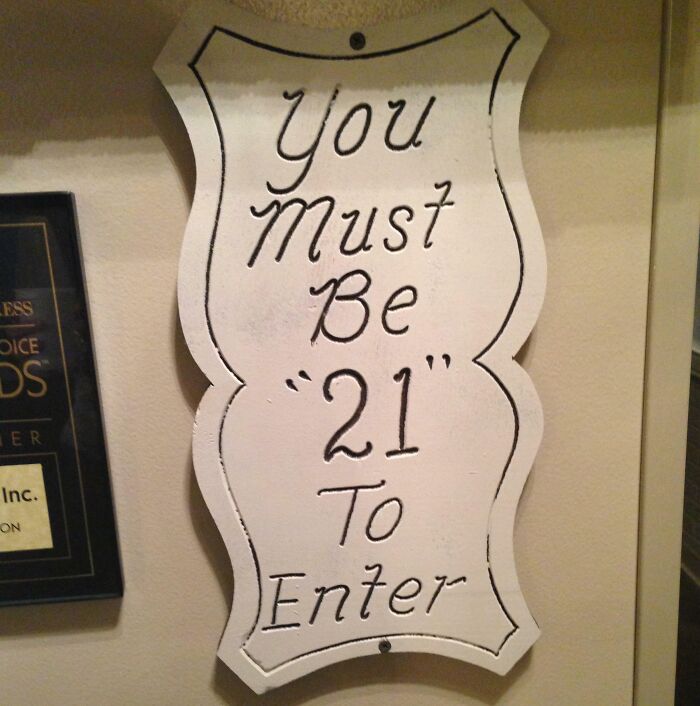 Sign with suspicious quotation marks around the number 21 humorously questioning age requirement to enter.