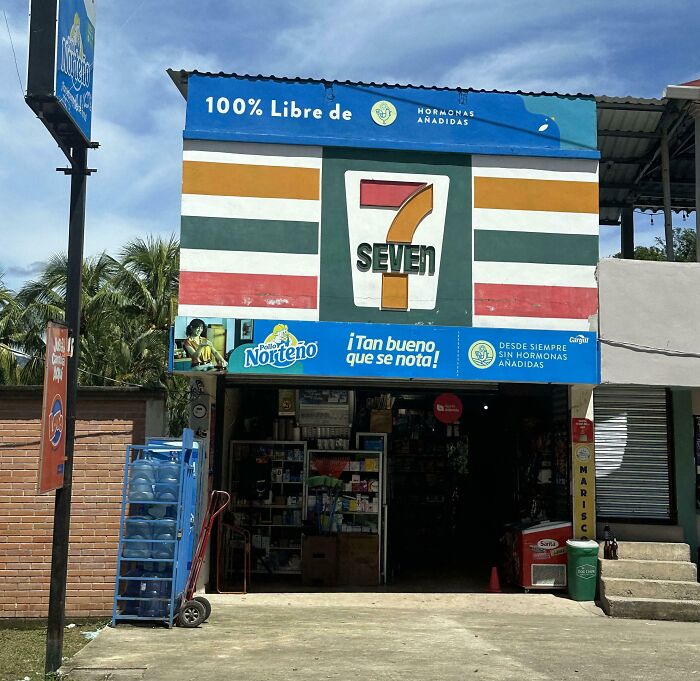 Small store with a shameless design copying famous 7-Eleven brand logo and colors on its storefront.