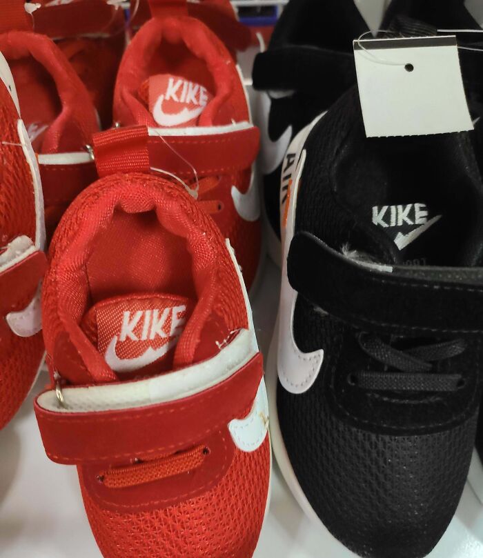 Red and black kids sneakers with the shameless sham brand KIKE copying famous Nike logos and style elements.