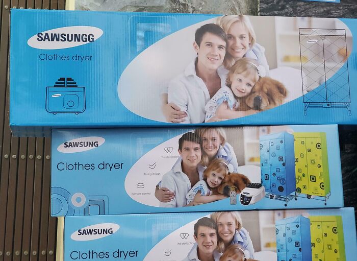 Boxes of clothes dryers branded as Sawsungg, a shameless copy of Samsung packaging with family photo and product images.