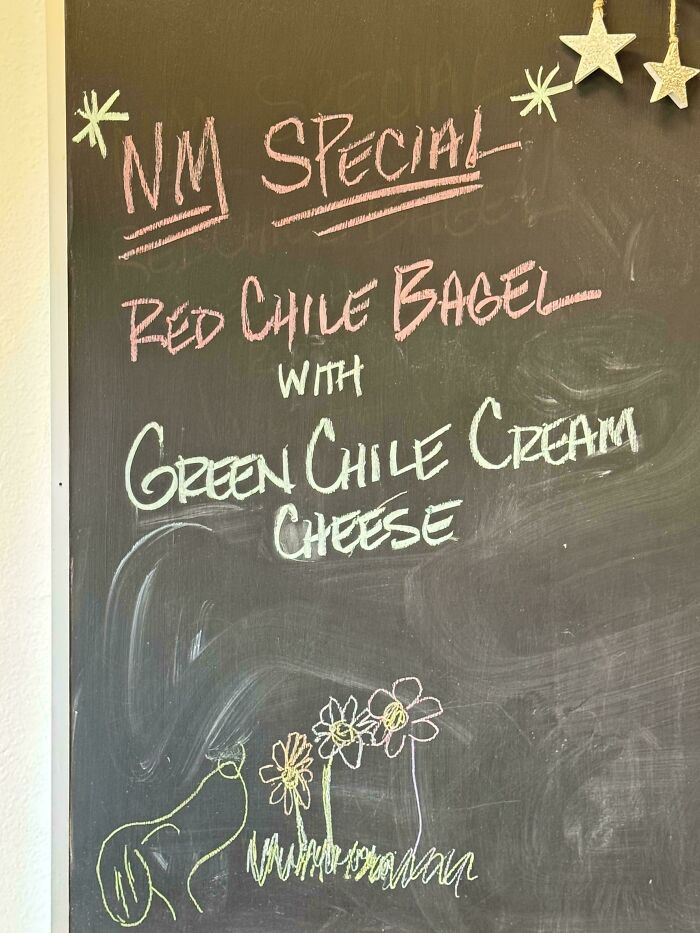 Chalkboard menu highlighting New Mexico special featuring red chile bagel with green chile cream cheese, capturing state essence.
