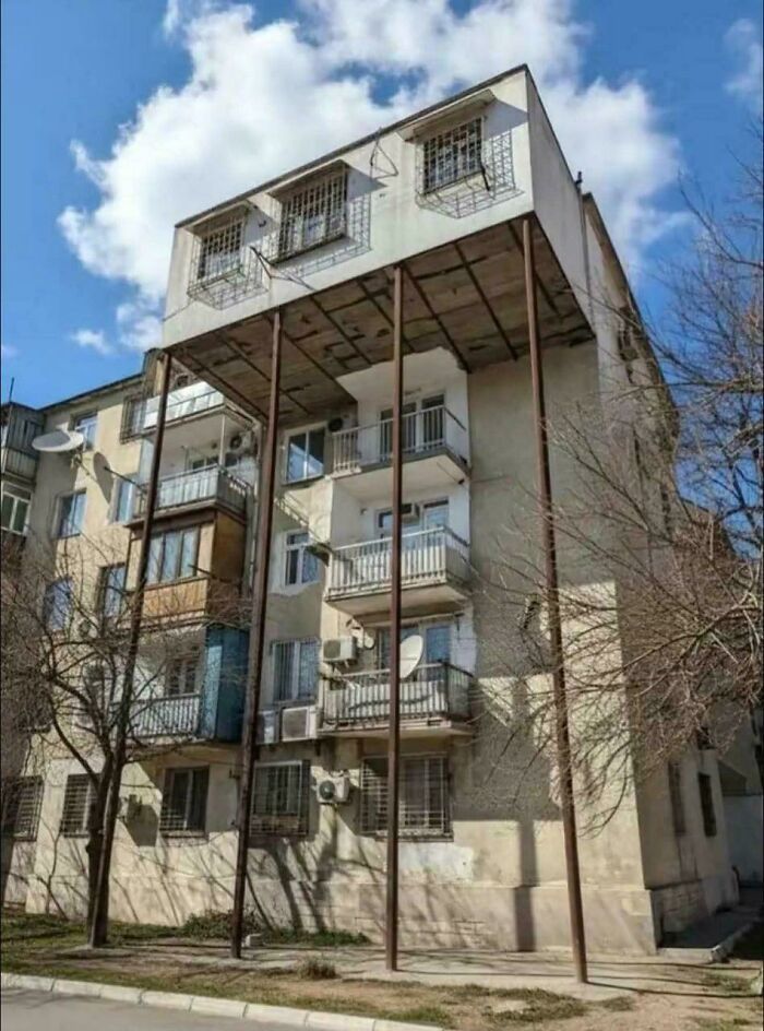 Unusual urban hell apartment with unsupported top floor held by metal poles
