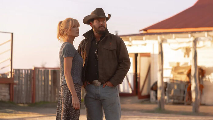 Two characters from Dutton Ranch stand outdoors at sunset, highlighting the show's release and its connection to Yellowstone.
