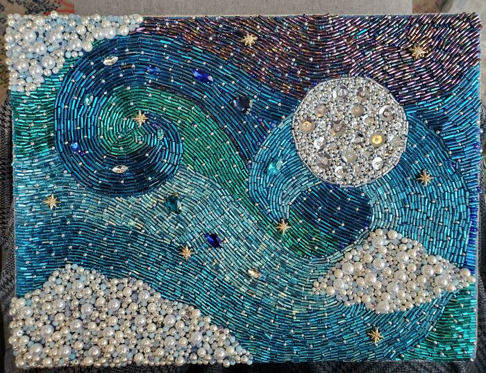 Vibrant embroidery creation using beads to form a starry night sky with a moon and clouds, inspiring hobby.