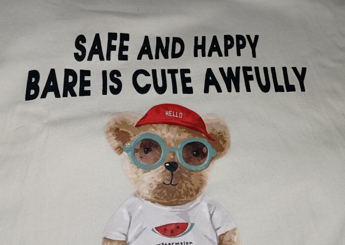 T-shirt with a bear wearing glasses and a red cap, featuring a hilariously bad design with mixed-up text.