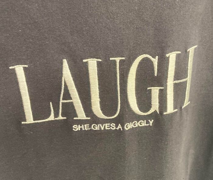 Close-up of a hilariously bad t-shirt design with the word LAUGH and misspelled phrase she gives a giggly.