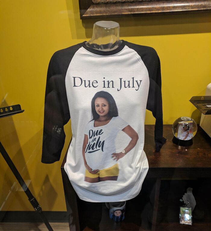 Black and white raglan t-shirt with hilariously bad design of a woman wearing a "Due in July" shirt creating an infinite loop.