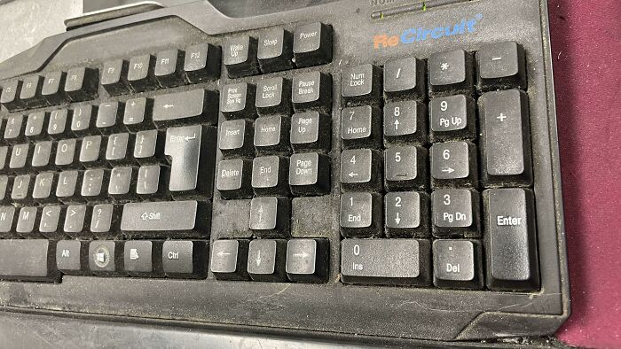 Dusty and worn office keyboard showcasing neglected workplace equipment in a declining work environment.