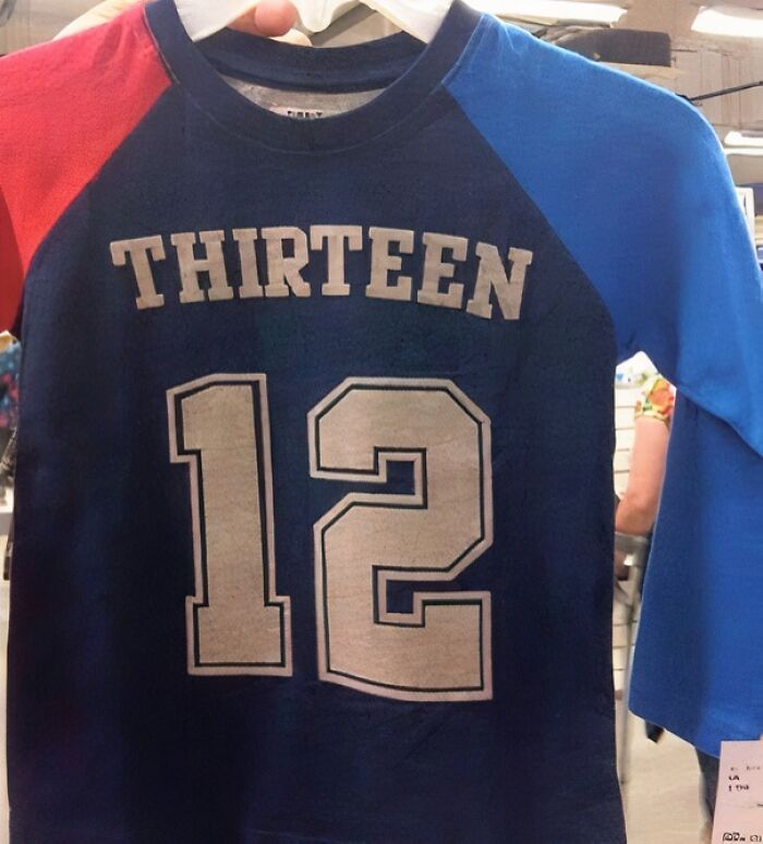 Funny failed t-shirt design showing the word thirteen above the number 12 on a red and blue shirt.