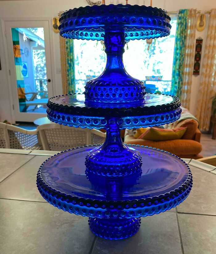 Three-tiered vibrant blue glass stand with textured dot patterns, perfect creative glass item for home decor or serving.
