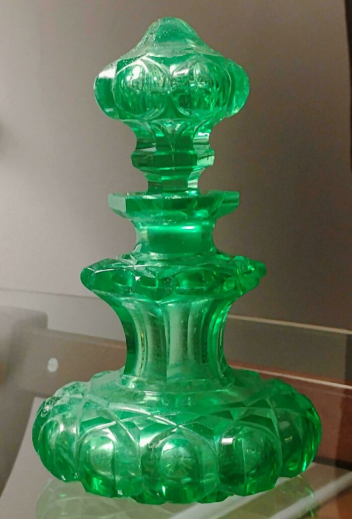 Green decorative glass bottle with intricate creative design, a unique glass item perfect for home decor collection.