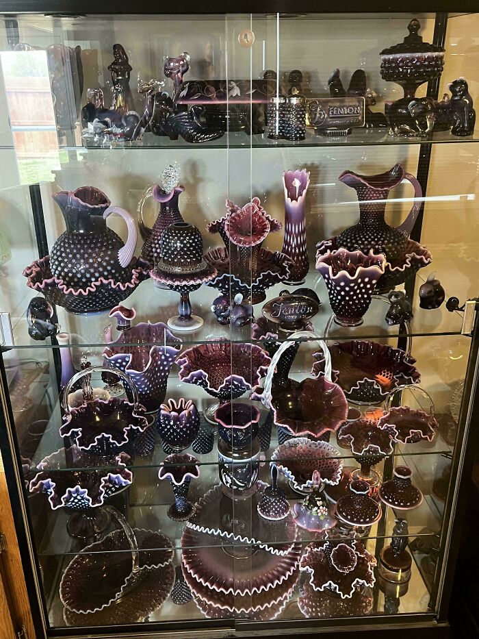Collection of creative glass items with intricate designs and ruffled edges displayed in a glass cabinet for home decor.