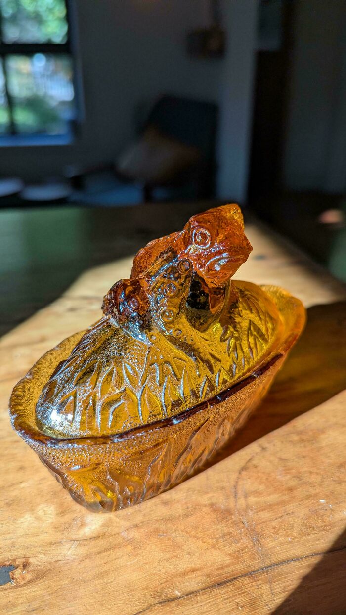 Amber glass dish with frog-shaped lid, a creative glass item showcasing detailed craftsmanship for home decor.