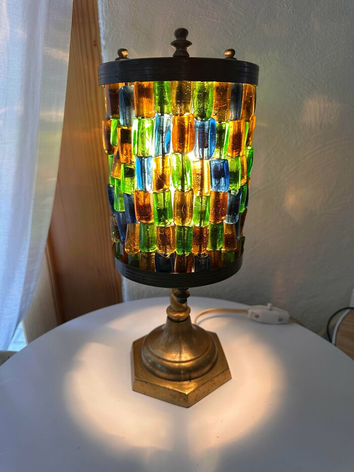 Colorful mosaic glass lamp with brass base glowing warmly, a creative glass item perfect for home decor and ambiance.