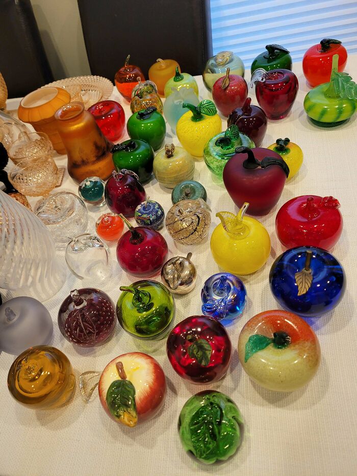 Collection of colorful and creative glass items shaped like fruits displayed on a table for home decor.
