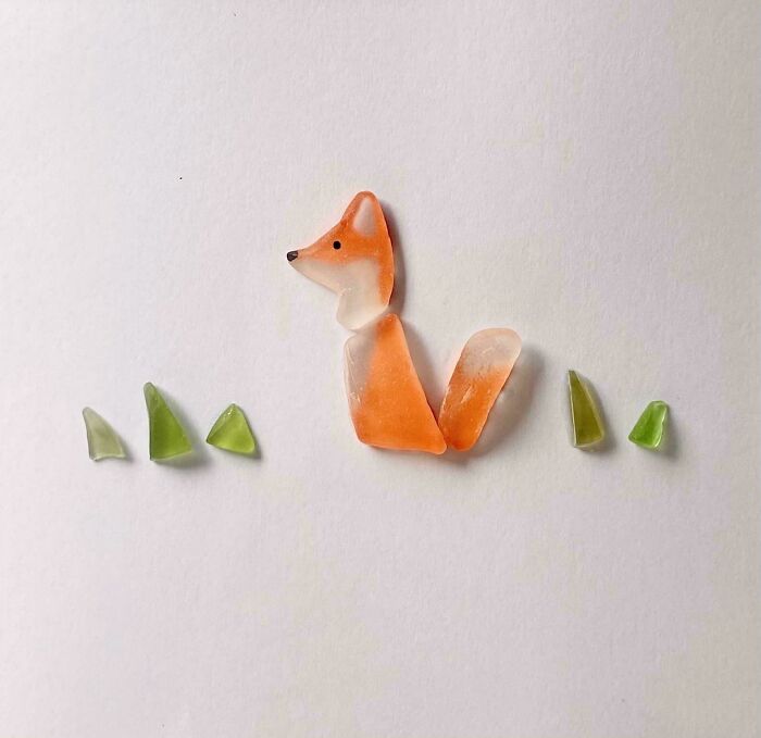 Small creative glass pieces arranged to form a fox with green glass accents, showcasing cool glass items for home decor.