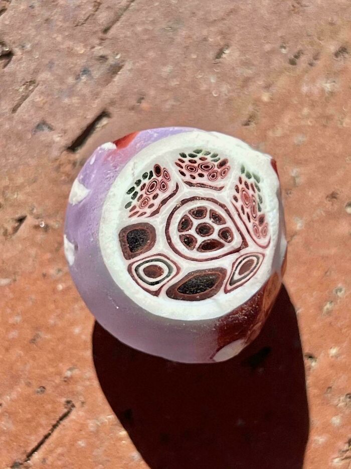 Close-up of a cool and creative glass item with intricate multicolored patterns on a textured surface.