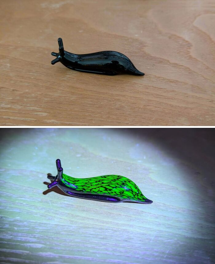 Handcrafted cool and creative glass snail figurine shown in natural and glowing light on wooden surface.