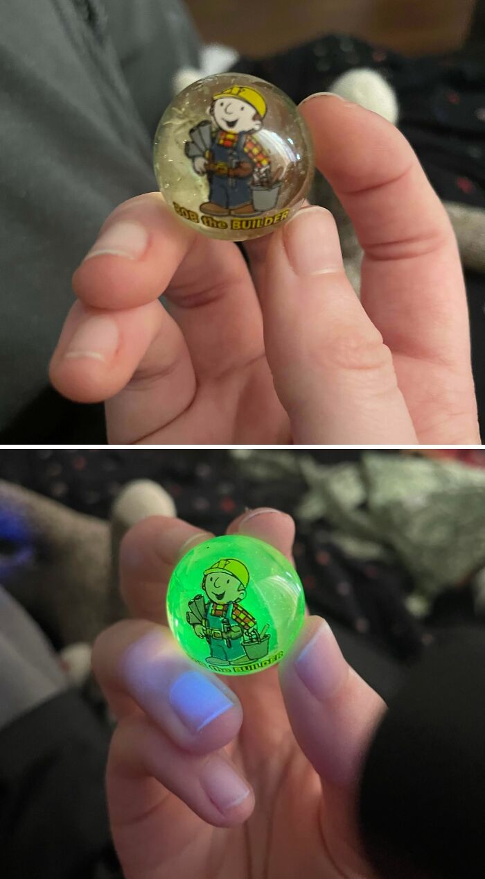 Hand holding glow-in-the-dark glass marble featuring a cartoon builder, a cool and creative glass item for home.