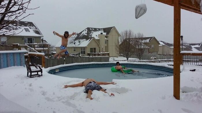 Three people enjoying a snowy backyard with a pool in winter, capturing the essence of US state lifestyles.
